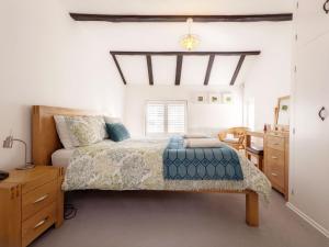 a bedroom with a bed and a desk and a mirror at Baytree Cottage, Walberton in Walberton