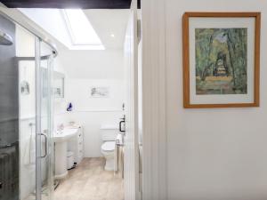 a bathroom with a toilet and a painting on the wall at Baytree Cottage, Walberton in Walberton +25 photos