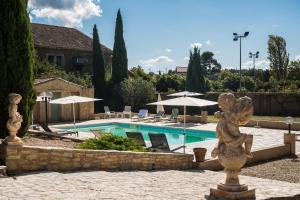 Castelnau-dʼAudeにあるLe gite de la closerie des irisの建物前の像付きスイミングプール