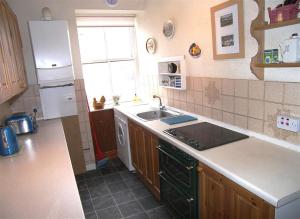 a kitchen with a sink and a stove top oven at 26 Castle Street in Kirkcudbright