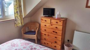 a bedroom with a dresser with a television on it at 26 Castle Street in Kirkcudbright