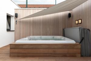 een jacuzzi in een badkamer met een houten muur bij B&B Herenhuis in Izegem