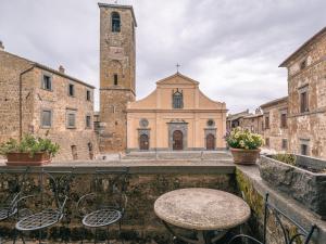 a table and chairs in front of a church at Locanda Della Buona Ventura in Bagnoregio