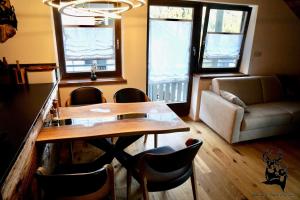 a dining room with a table and chairs and a couch at Apartment-Chalet Panorama in Todtmoos