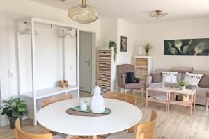 a living room with a white table and chairs at fewo1846 Strandresidenz Wassersleben - OstseeNest - modernes Studioapartment mit Balkon am Strand in Harrislee +9 photos