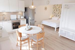 a kitchen and dining room with a table and chairs at fewo1846 Strandresidenz Wassersleben - OstseeNest - modernes Studioapartment mit Balkon am Strand in Harrislee