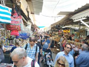 uma multidão de pessoas caminhando através de um mercado em bugrashov 13 room em Tel Aviv