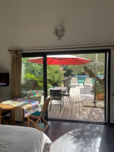 1 dormitorio con patio con mesa y sombrilla en Sous les oliviers - Piscine chauffée à débordement- Charming en Saint-Maximin-la-Sainte-Baume