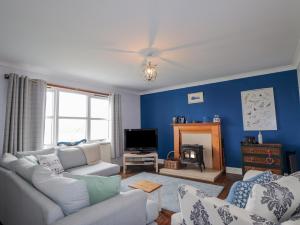 a living room with a white couch and a blue wall at Hilltop House in Staffin