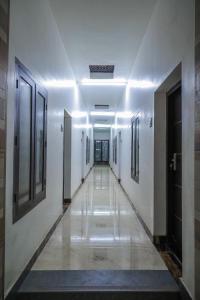 a corridor of a building with white walls and a hallway at Royal Lodge in Nāgercoil