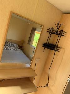 Dormitorio pequeño con espejo en la pared en Loch Heron View en Newton Stewart