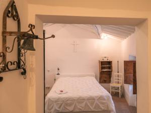 ein Schlafzimmer mit einem Bett und einem Kreuz an der Wand in der Unterkunft Locanda Della Buona Ventura in Bagnoregio