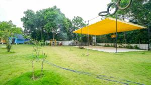 ein großer gelber Baldachin in einem Hof mit Spielplatz in der Unterkunft Bavi Myan Maison 