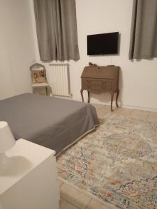 1 dormitorio con 1 cama, TV y mesa en Gioberti, en Casale Monferrato