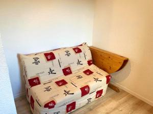 a bed with four pillows with asian writing on it at Studio cosy à Uvernet-Fours / 15 m² / Vue montagne in Uvernet-Fours