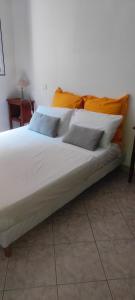 1 cama grande con sábanas blancas y almohadas. en Belle maison de charme ancien, vue mer et montagne en Casalabriva