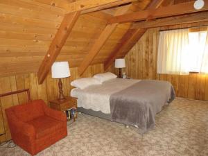 um quarto com uma cama e uma cadeira num camarote em Lakeside BLS Retreat near Big Trees & Bear Valley em Arnold