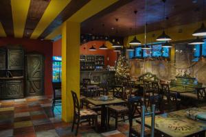 a restaurant with tables and chairs and a christmas tree at Hotel Monysto in Bukovel