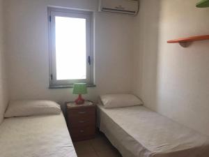 two twin beds in a room with a window at San Rocco residence two bed apartments 5B2 5 in Isca sullo Ionio +23 photos