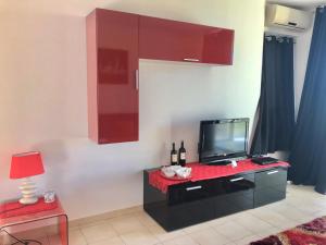 a living room with a television and a table with a lamp at San Rocco residence two bed apartments 5B2 5 in Isca sullo Ionio