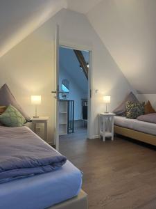 1 dormitorio con 2 camas y 2 lámparas en el ático en Spatzennest und Rabennest, en Sugenheim