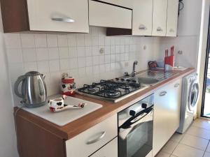 a small kitchen with a stove and a sink at San Rocco residence two bed apartments 5B2 5 in Isca sullo Ionio