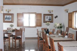 comedor con mesas y sillas y 2 ventanas en Casa d Toninha - Casas de Campo - Turismo Espaço Rural - AL, en Sernancelhe