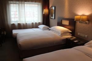 Postel nebo postele na pokoji v ubytování Sunworld Hotel Wangfujing