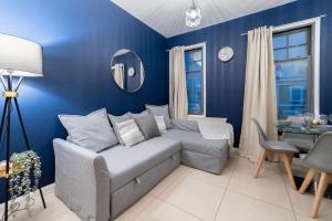 a blue living room with a couch and a table at (Kensington Museum) 2 bedroom apartment London in London