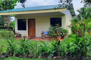 a small house with a patio in front of it at Granja Agua Azul.A/C WiFi,2 Camas, Rio, jardines. in Fortuna