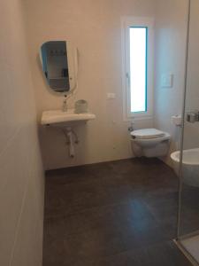 La salle de bains est pourvue de toilettes, d'un lavabo et d'un miroir. dans l'établissement Casa Vittoria Guest House, à Romano D'Ezzelino