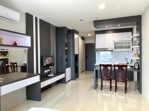 a kitchen with a bar with chairs and a table at Wiwi Formosa Residence Nagoya Batam in Nagoya