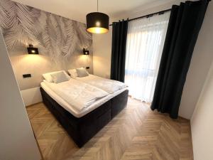 a bedroom with a bed and a large window at Apartament na Zielonej Szczytno Mazury in Szczytno