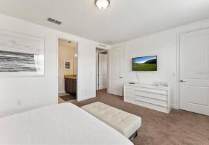 a white bedroom with a bed and a tv at 371 P Luxury Villa- New Listing in Orlando +31 photos