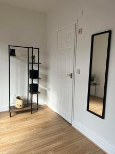um quarto com um espelho e uma porta branca em Cheerful 5 Bedrooms & En-Suite Bathrooms Town House em Northampton