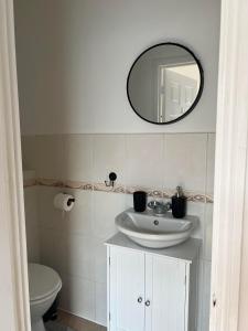 a bathroom with a sink and a mirror at Cheerful 5 Bedrooms & En-Suite Bathrooms Town House in Northampton