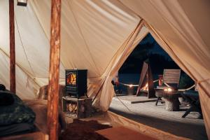 a tent with a stove and a fire in it at Vristulvens Glamping in Mariestad