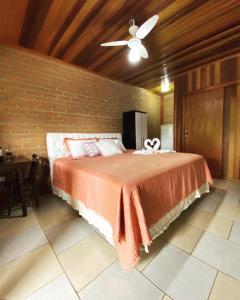 a bedroom with a bed and a brick wall at Chalés Sapucaí Pousada in São Bento do Sapucaí