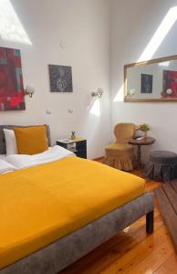 Un dormitorio con una gran cama amarilla y una mesa en The Only One Apartments, en Niš