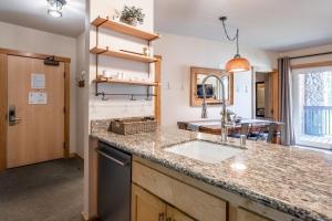 uma cozinha com um lavatório e uma bancada em Ski in Ski Out Juniper Springs Lodge #351 Luxury Slope-side 2 Bedrm 2 Bath End Unit! em Mammoth Lakes