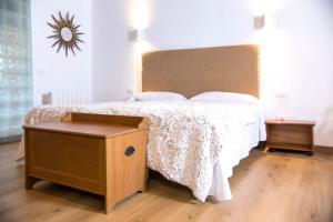 Un dormitorio con una cama grande con cabecero de madera. en Hotel Rural El Refugio - Adults Only, en Tejeda