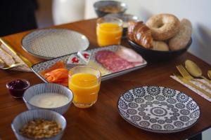 uma mesa coberta com pratos de comida e copos de sumo de laranja em Logement In de Peel em Griendtsveen