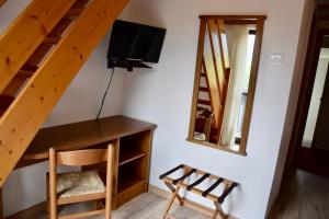 een kamer met een trap, een tv en een stoel bij Hotel Ferrari in Pinzolo