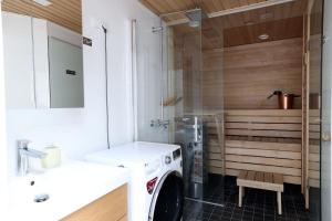 a washing machine in a bathroom with a sink at 2ndhomes Unique 35m2 Studio Penthouse with Sauna & Balcony in Helsinki