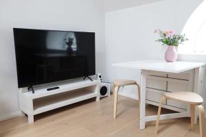 uma sala de estar com uma televisão e uma mesa e cadeiras em 2ndhomes Unique 35m2 Studio Penthouse with Sauna & Balcony em Helsínquia
