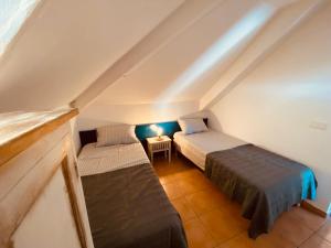 Cette chambre mansardée comprend deux lits et une table. dans l'établissement Tucum Home - Appart au Village Vacances Sainte Anne, à Sainte-Anne