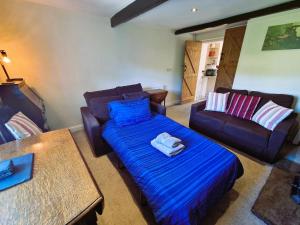 a living room with a bed and a couch at Crosland Cottage in Holmfirth