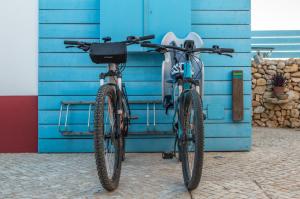 uma bicicleta estacionada em frente a uma parede azul em Cercas Velhas em Sagres