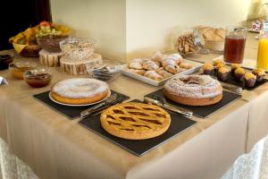 a table with different types of cakes and pastries at Hotel Ferrari in Pinzolo