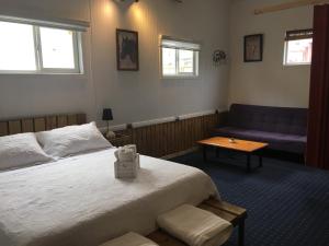 1 dormitorio con cama, sofá y mesa en Hostal El Mesón en Punta Arenas